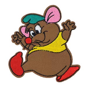 May include: Embroidered patch featuring a cartoon mouse with brown fur, pink ears, and a red nose. The mouse wears a yellow shirt and a green cap, with red shoes. The design is outlined in black and appears to be jumping.