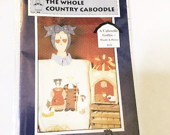 以下が含まれることがあります： "Caboodle Gothic" プロジェクトのクラフトパターンで、カップル、農家、そして「Humpty Dumpty」と書かれた看板が描かれています。パターンは「The Whole Country Caboodle」というタイトルで、番号は #151 です。