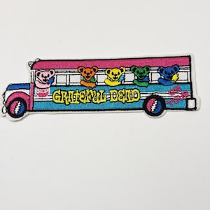 Puede incluir: Parche bordado con un autobús colorido con la inscripción "Grateful Dead" y osos bailarines. El autobús es azul, rosa y blanco, con osos rosas, naranjas, amarillos, verdes y azules. El parche dice "On Tour".