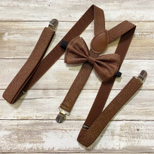 Peut inclure: Bretelles marron avec un nœud papillon marron assorti. Les bretelles et le nœud papillon ont une finition scintillante.