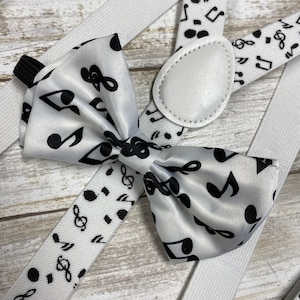 May include: White bow tie with black musical notes and a white suspender with black musical notes.