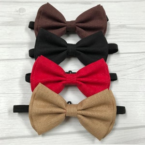 May include: Four bow ties in different colors: brown, black, red, and beige. The bow ties are made of fabric and have adjustable straps.
