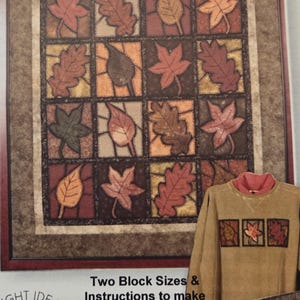 May include: A pattern for "Stained Glass Leaves" with a grid of colorful autumn leaves. The design includes instructions for wall hangings or sweatshirt designs. The text reads "Bright Ideas Design Co."