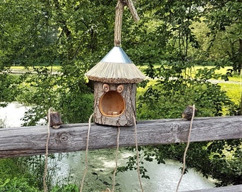 Vogelhaus Futterhaus gefertigt aus einem Baumstamm mit Reetdach