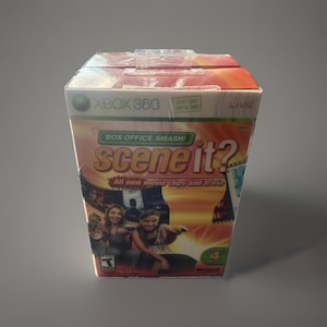 May include: A factory-sealed Xbox 360 video game titled Scene It? Box Office Smash! The packaging features a vibrant orange and yellow background with movie film strips, two people holding controllers, and the text All new movie clips and trivia.