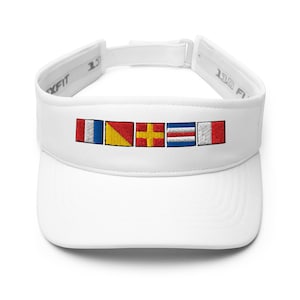 May include: White visor with embroidered nautical flags in red, yellow, blue, and white. The visor has an adjustable strap and a curved brim. The flags are arranged horizontally across the front of the visor.