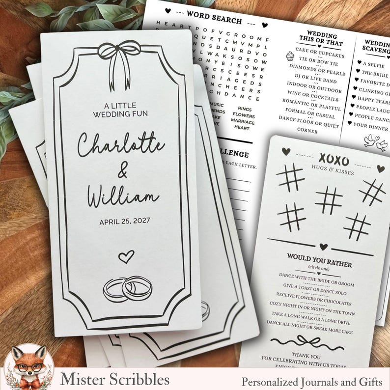 K&ouml;nnte beinhalten: Ein Stapel wei&szlig;er Hochzeitsspielkarten mit schwarzem Text und Illustrationen. Die Karten zeigen eine Schleife, Ringe und die Namen "Charlotte & William" mit dem Datum "25. April 2027". Weitere Karten enthalten Wortsuch- und Spielaufforderungen.
