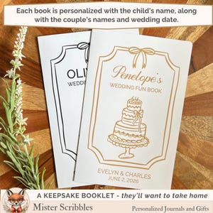 May include: Two white paper booklets with gold and black line art illustrations. The front booklet features a gold frame, a three-tiered cake, and the text Penelope's WEDDING FUN BOOK, EVELYN & CHARLES, JUNE 2, 2026. The second booklet shows a black frame.