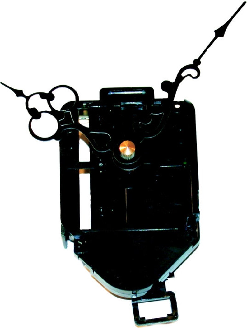 May include: Black clock movement with a gold knob and black hands. The hands are designed with a decorative flourish.