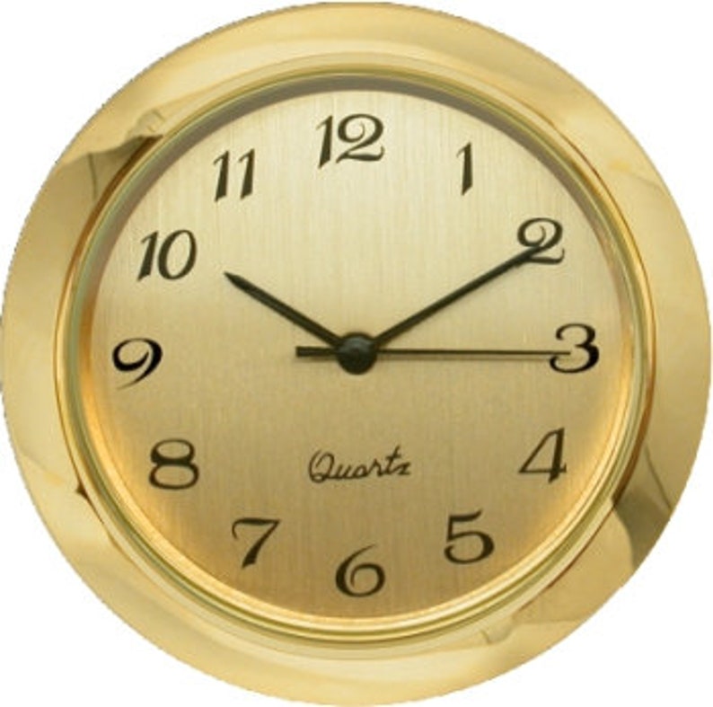 Pu&ograve; includere: Quadrante dell'orologio color oro con lancette delle ore e dei minuti nere e numeri arabi neri. Il quadrante dell'orologio riporta la scritta "Quartz".