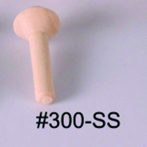 May include: A wooden dowel with a rounded top. The dowel is light brown in color and has a #300-SS label.