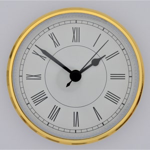 May include: A gold-rimmed clock face with Roman numeral hour markers and black hands. The clock face is white with a subtle silver sheen.