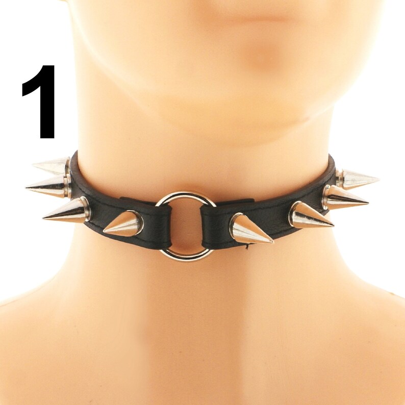 Discover our chic black choker crafted from vegan faux leather with a spiked punk rock design. Featuring a ring detail and adjustable buckle closure.