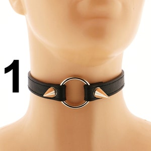 Embrace a punk or rock style with this fashionable choker made from vegan leather. Its sleek design includes a heart ring, spiked accents, and an adjustable buckle closure, all in a striking all-black color.