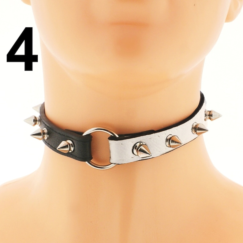 Unleash your inner fashionista with our opulent chic choker range. Meticulously crafted from vegan faux leather in white and black, showcasing a mesmerizing heart ring detail and rebellious spiked punk rock design.