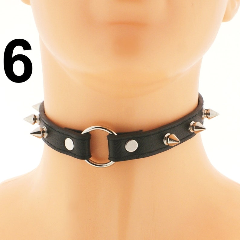 Discover our stylish black choker crafted from vegan faux leather with edgy ring detail and punk rock spiked design. Features adjustable buckle closure.