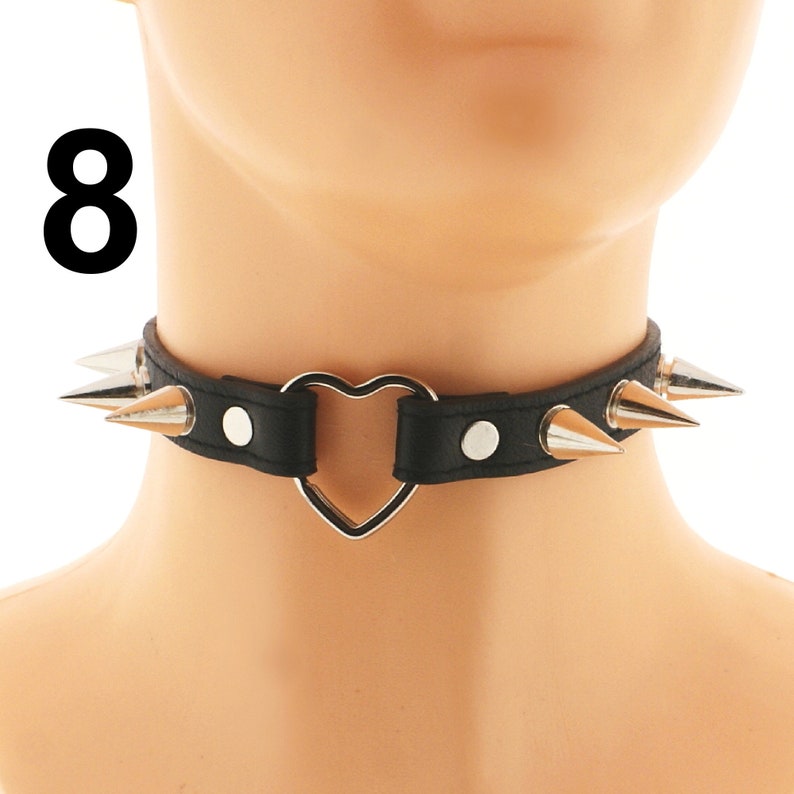 Unveil the trendy black choker on our website. This vegan faux leather piece features a unique ring detail and a spiked punk rock design, along with an adjustable buckle closure.