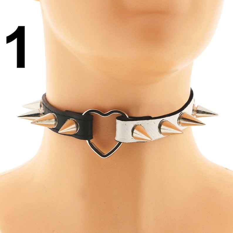 Discover the epitome of elegance with our chic choker collection. Crafted from vegan faux leather in white and black, adorned with a heart ring detail and spiked punk rock design. Adjustable buckle closure for a perfect fit. Indulge in luxury today!
