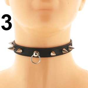 Explore our fashionable black choker. Made of vegan faux leather, it boasts a chic ring detail and a punk rock-inspired spiked design. Adjustable buckle closure.