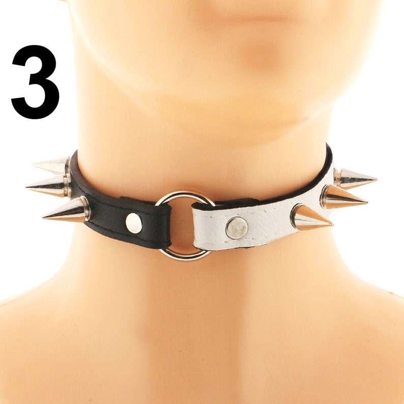 Immerse yourself in the world of luxury with our exclusive chic choker assortment. Handcrafted from vegan faux leather in white and black, adorned with a captivating heart ring detail and daring spiked punk rock design.