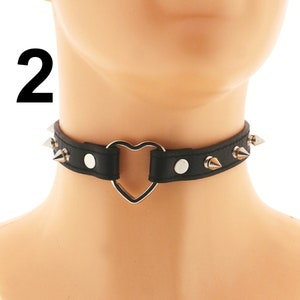 Show off your individuality with our Black Vegan Leather Spiked Punk Choker. This women's collar necklace includes faux leather, spikes, and an adjustable buckle closure for a daring and stylish appearance.