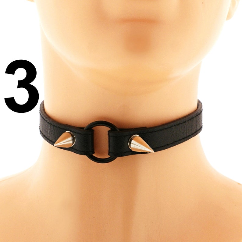 Add a touch of punk or rock flair to your ensemble with this chic choker. Made from vegan leather, it boasts a stylish heart ring, spiked accents, and an adjustable buckle closure, all in a versatile all-black shade.