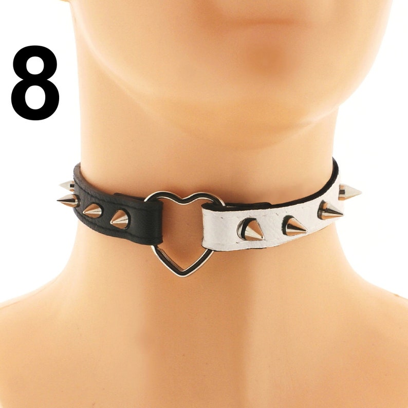 Elevate your style with our exquisite chic choker selection. Impeccably crafted from vegan faux leather in white and black, featuring a captivating heart ring detail and edgy spiked punk rock design.