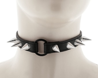 the choker collar has a ring and spikes and a buckle closure necklace made of all black faux leather for a punk or rock style
