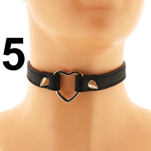 This vegan leather choker is the perfect accessory for those who love punk or rock styles. Featuring a heart ring, spiked design, and adjustable buckle closure, all in a bold all-black color, it adds a touch of edgy flair to any outfit.