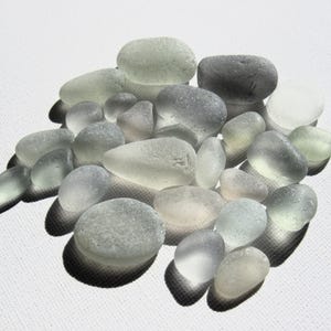 ¡Pepitas de vidrio marino en tonos grises! Juego de 26 piezas de vidrio de playa, desgastadas naturalmente por las olas, con formas inusuales de círculos y óvalos.