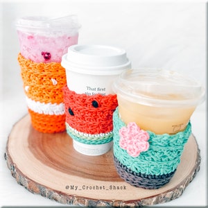 Puede incluir: Tres forros para bebidas de ganchillo en diferentes colores y patrones. Los forros están sobre una superficie de madera. Los forros están decorados con un diseño de sandía, un diseño de flores y un diseño a rayas. El texto "That first sip feeling" está en el diseño de sandía.