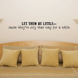 May include: A bedroom with a wooden headboard and a quote on the wall that reads "LET THEM BE LITTLE... cause they're only that way for a while."