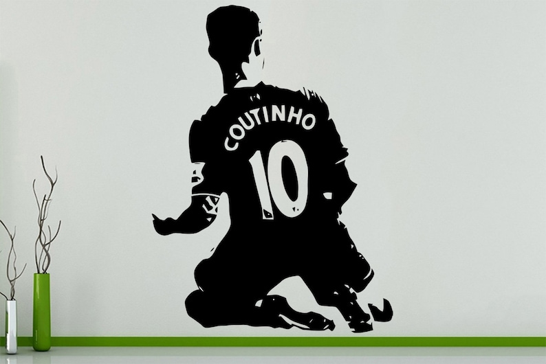 May include: Black and white silhouette of a soccer player kneeling with the name "Coutinho" and the number "10" on the back of their jersey.