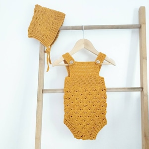 May include: A mustard yellow crocheted baby romper with wooden buttons and matching crocheted bonnet.