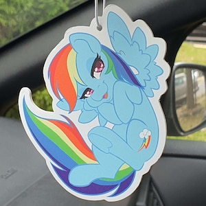 May include: A blue and rainbow-colored cartoon pony with a pink mane and tail. The pony is sitting on its haunches with its wings spread out behind it. The pony has a rainbow-colored cloud on its flank.