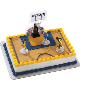 Peut inclure: Un g&acirc;teau blanc d&eacute;cor&eacute; d'un terrain de basket-ball, avec un panier de basket, trois joueurs de basket-ball et le texte "GO TEAM!"