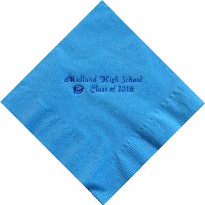 May include: A square, light blue napkin with the text "Midland High School Class of 2016" printed in dark blue. A graduation cap graphic is also included. The napkin is folded diagonally.