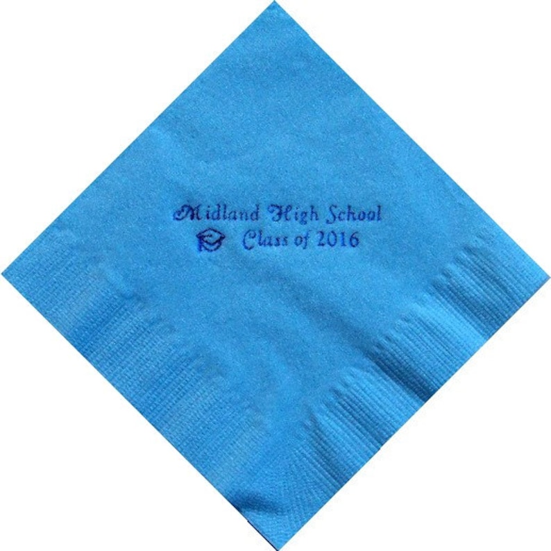 May include: A square, light blue napkin with the text "Midland High School Class of 2016" printed in dark blue. A graduation cap graphic is also included. The napkin is folded diagonally.