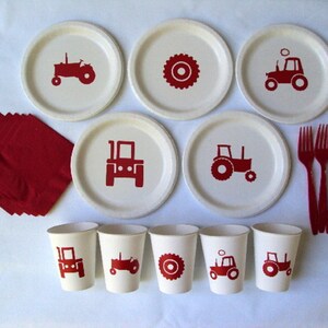 May include: A set of red and white tractor themed party supplies, including paper plates, cups, napkins, and forks. The plates feature a red tractor design, while the cups have a tractor or wheel design. The napkins are red and the forks are red plastic.