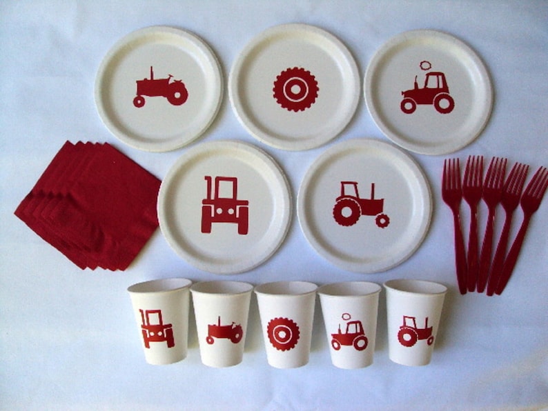 May include: A set of red and white tractor themed party supplies, including paper plates, cups, napkins, and forks. The plates feature a red tractor design, while the cups have a tractor or wheel design. The napkins are red and the forks are red plastic.
