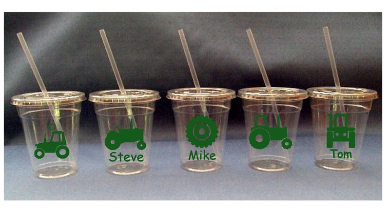 May include: Five clear plastic cups with green tractor designs and names "Steve", "Mike", and "Tom" printed on them. Each cup has a straw.