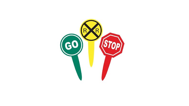 Op de afbeelding: Drie verkeersborden op een witte achtergrond. Een groen bord met "GO" in wit, een geel bord met een spoorwegovergangsymbool en een rood achthoekig bord met "STOP" in wit.