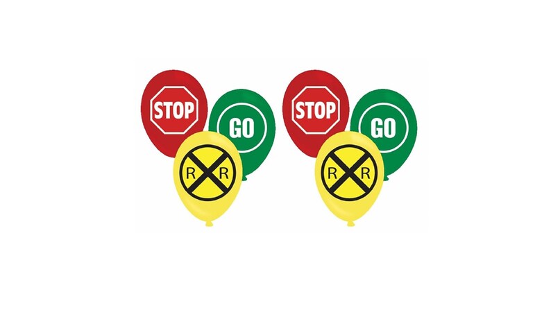 Op de afbeelding: Een verzameling ballonnen met verkeersthema's. De ballonnen tonen de woorden "STOP" in rood, "GO" in groen en een gele ballon met een spoorwegovergangssymbool. Dit zijn feestversieringen.