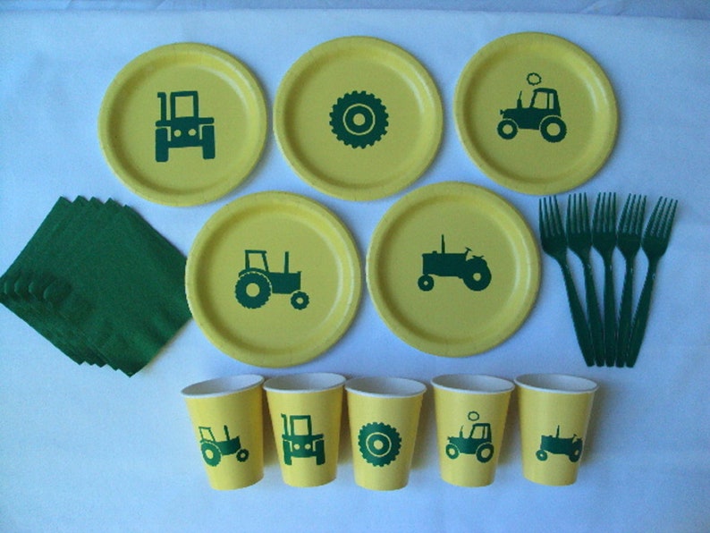 May include: A set of green and yellow tractor themed party supplies. The set includes plates, cups, napkins, and forks. The plates and cups feature a green tractor silhouette. The napkins are green and the forks are green.