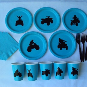 Puede incluir: Un conjunto de art&iacute;culos para fiestas azules y negros con la silueta de una persona conduciendo un quad. El conjunto incluye platos, vasos, servilletas y tenedores.