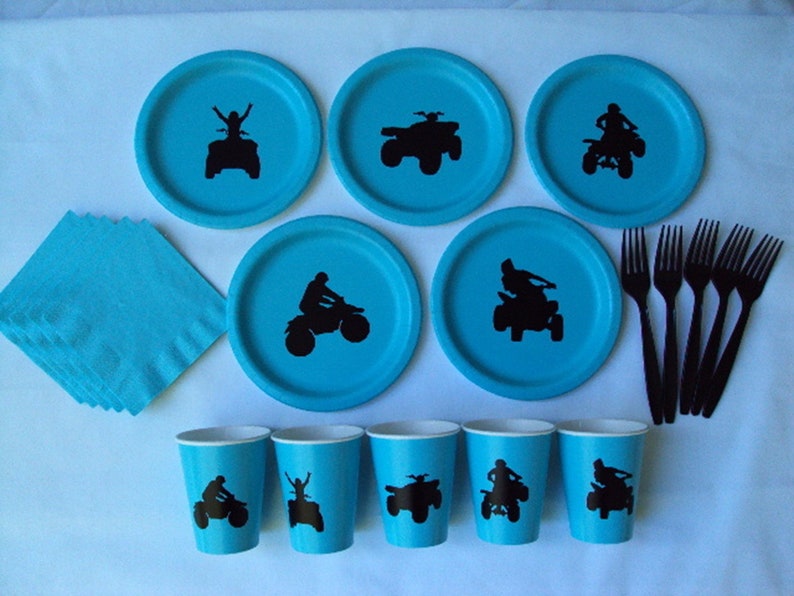 Puede incluir: Un conjunto de art&iacute;culos para fiestas azules y negros con la silueta de una persona conduciendo un quad. El conjunto incluye platos, vasos, servilletas y tenedores.