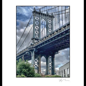 May include: A low angle view of the Manhattan Bridge in New York City. The bridge is made of steel and has a gray color. The bridge is seen from underneath, with the sky and clouds visible through the structure.