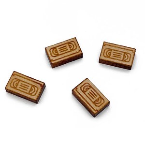 May include: Four wooden rectangular tiles with a vintage VHS cassette tape design. The tiles are light brown and have a slightly distressed look.