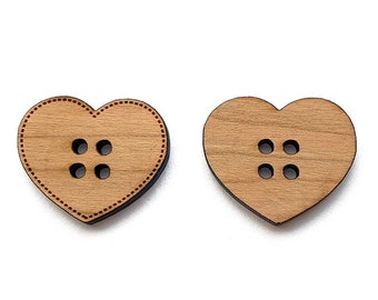 May include: Two wooden heart-shaped buttons with four holes each. One button has a red stitched border.