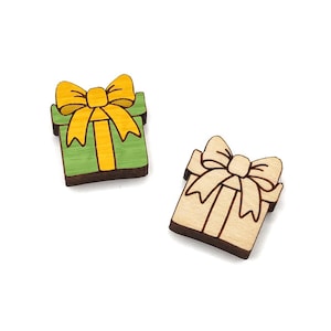 May include: Two wooden gift box ornaments, one green with a yellow bow and one natural wood with a brown bow.